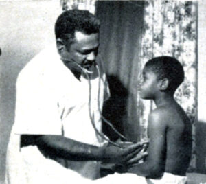 black and white photo of buddy treadwell holding a stethoscope to a child's chest